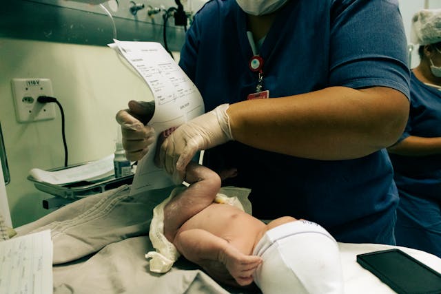 Can I Get a Birth Certificate Same Day? How Possible Is It? 3 A doctor stamps a birth certificate with a child’s foot.