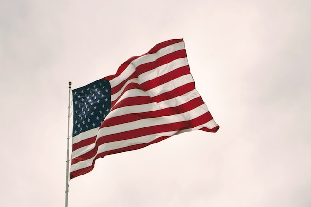 Чи потрібно перекладати свідоцтво про народження для USCIS 3 США розмахують прапором на флагштоці.