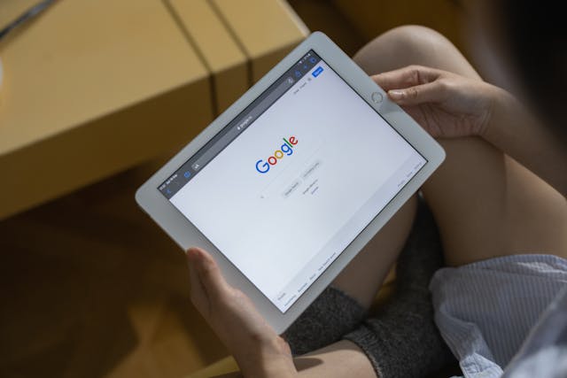 DeepL vs Google Translate:哪个更好?5 一个人手持 iPad,打开 Google 主页